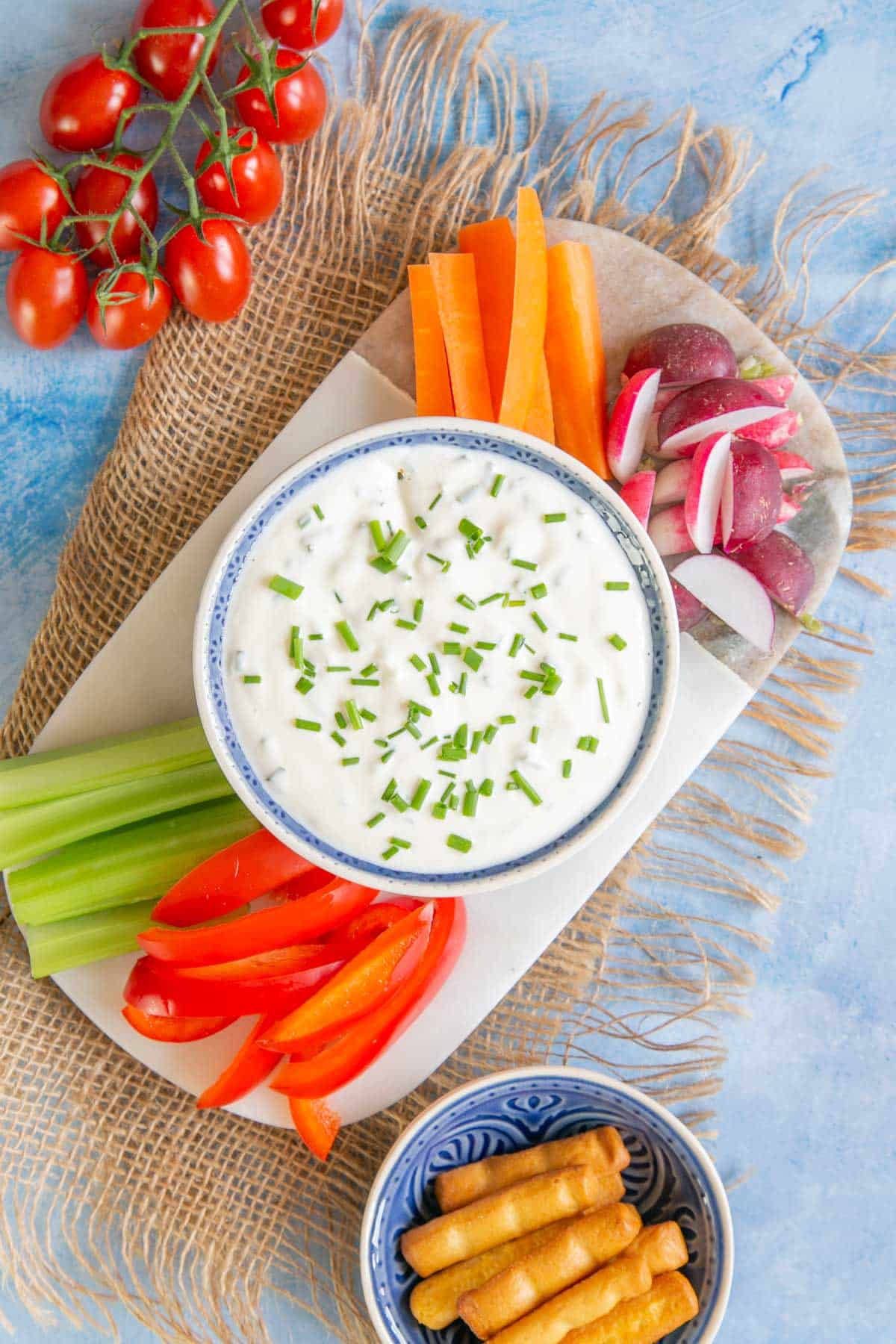 Cool, creamy, delicious sour cream and chives dip served on a platter with mixed crudités