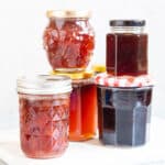 five jars of assorted jam and jelly
