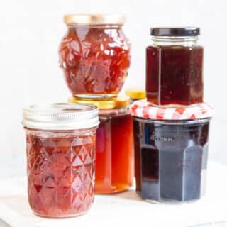 five jars of assorted jam and jelly