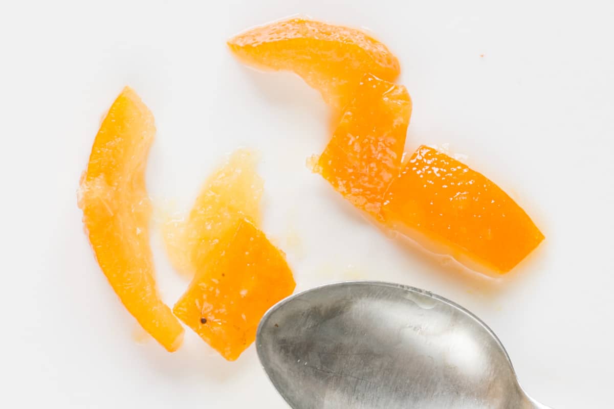 Testing orange peel by cutting it with a spoon.