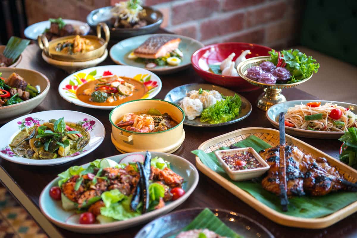 A table spread with a variety of Thai dishes.
