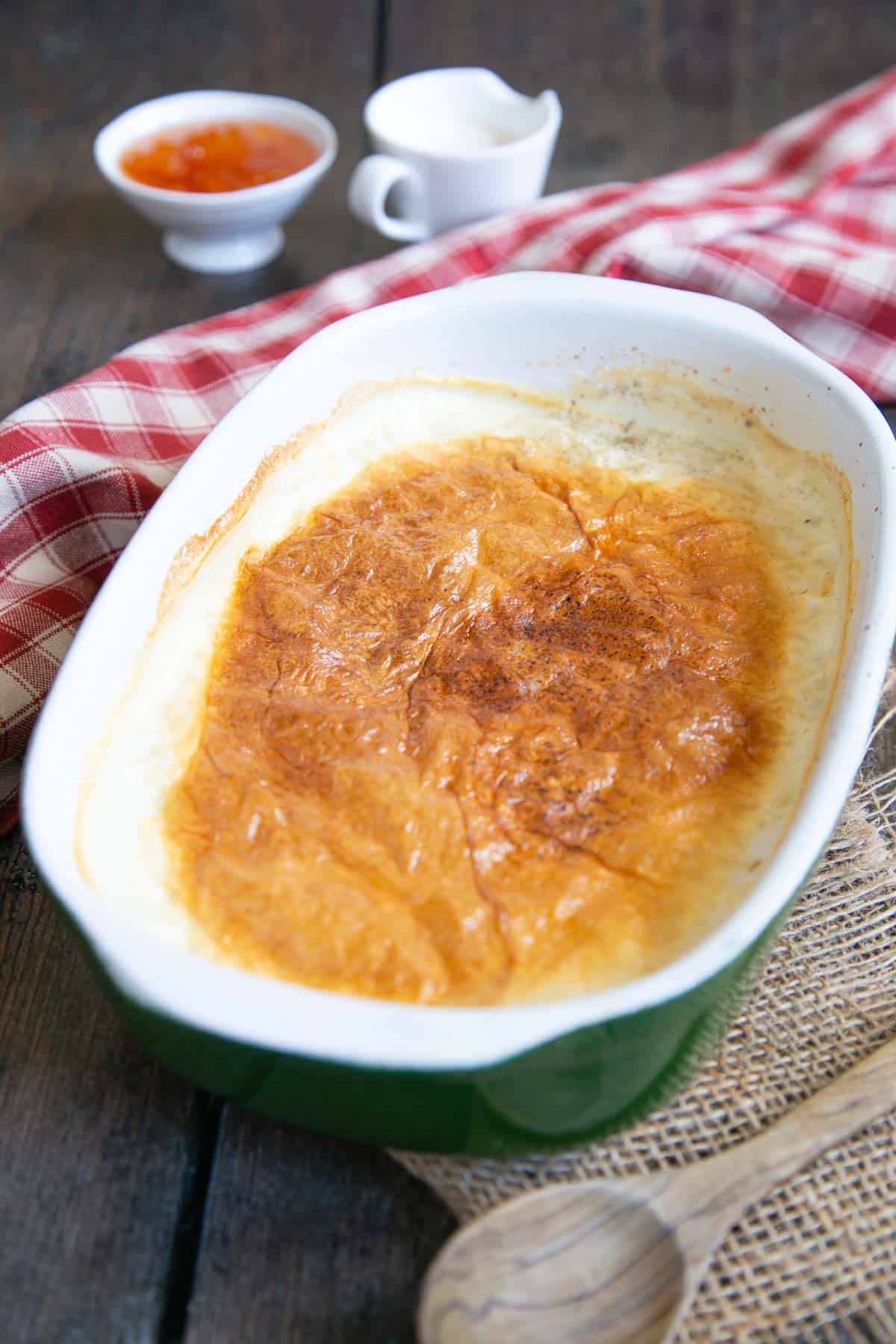 A dish of baked rice pudding ready to serve, showing the delicious brown crust.