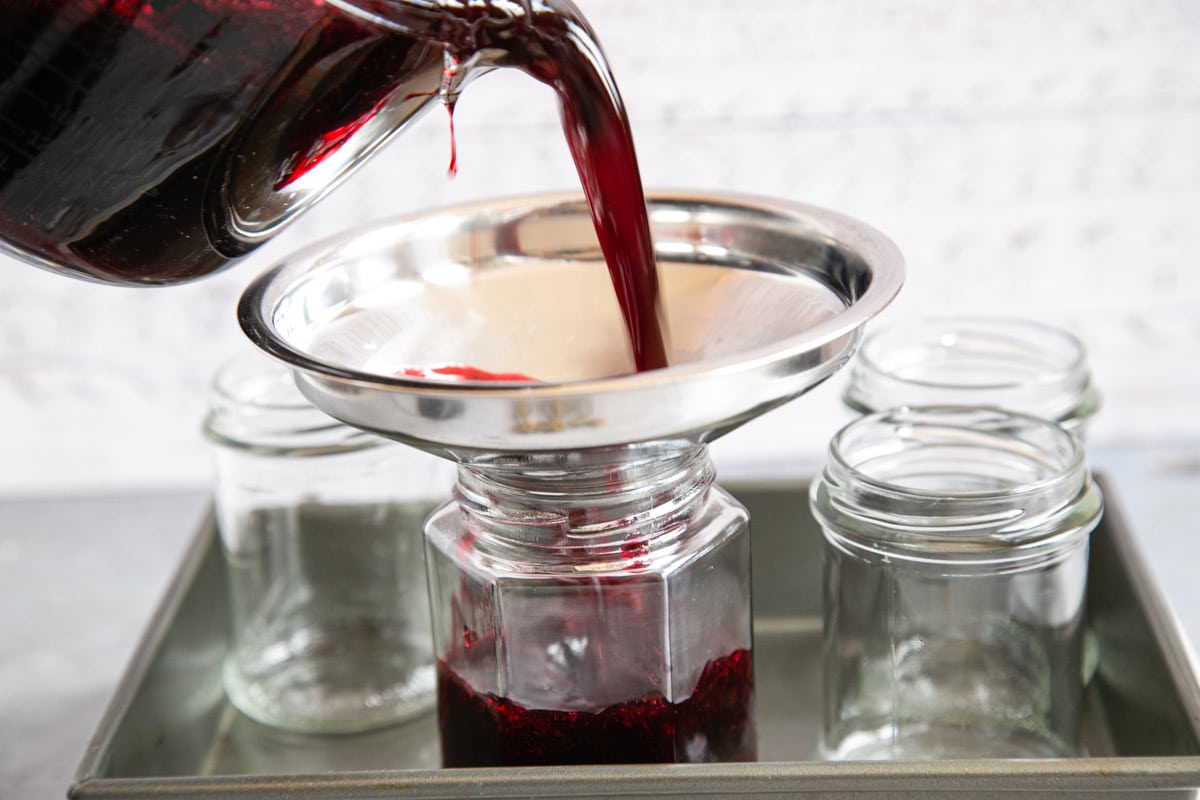 Pouring jam into heated jam jars.