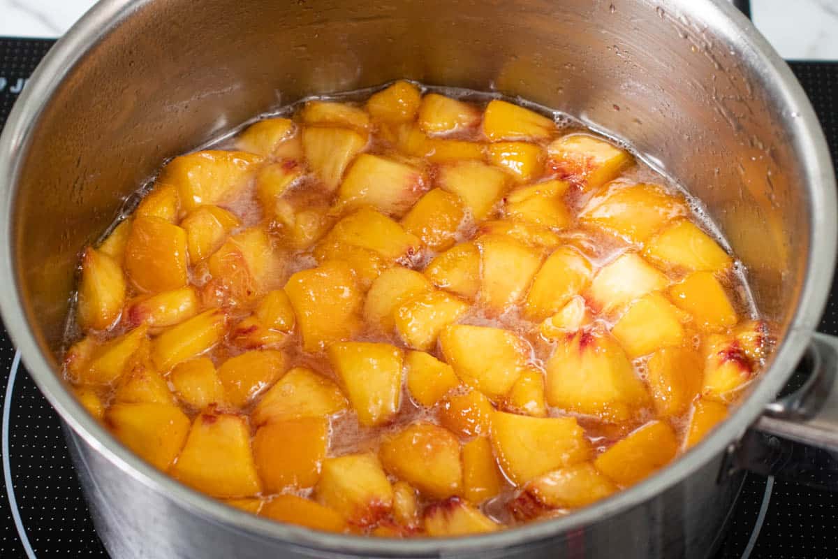 gently heating the peaches to dissolve the remaining sugar