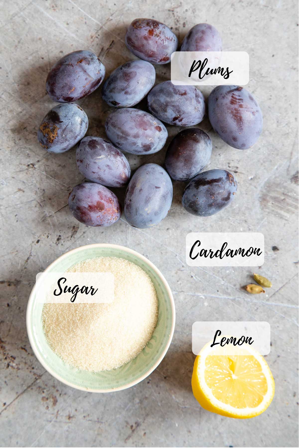 Plum compote ingredients: plums, lemon, sugar, and cardamon seeds.