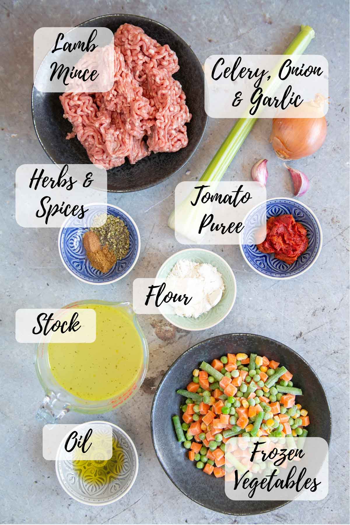 Ingredients for savoury lamb mince: oil, onion, garlic and celery, herbs and spices, flour, lamb mince, stock, tomato puree, and frozen vegetables.