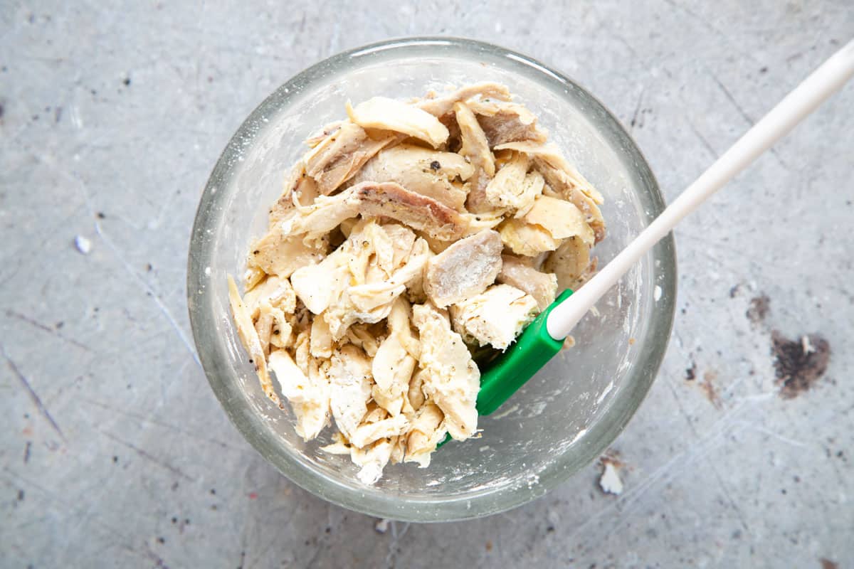 The bite-sized chunks of turkey are mixed with cornflour and seasoned, in a bowl.