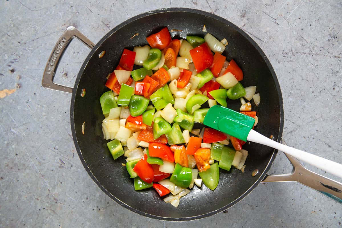 Frying onion and peppers in a large non-stick frying pan.
