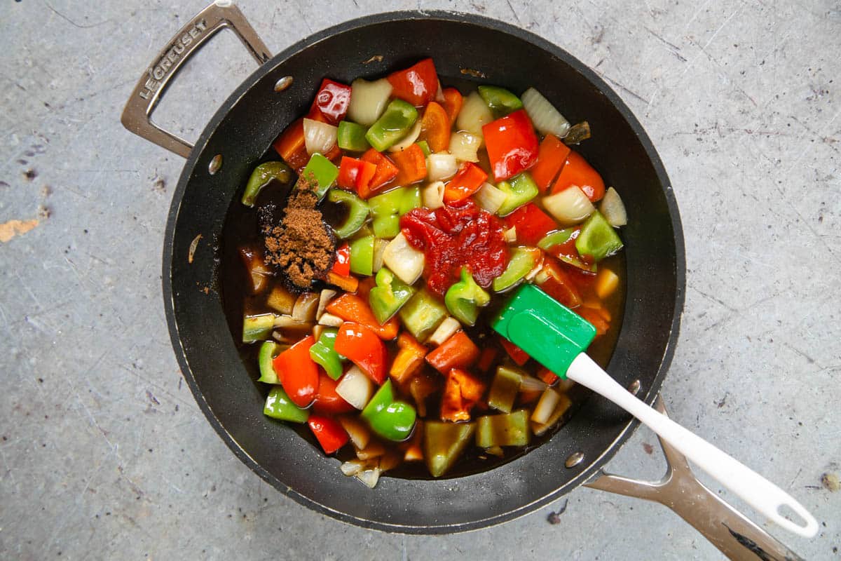 Next, the pineapple juice, vinegar, sugar, soy sauce and chilli sauce are added to the cooked peppers and onion in the non-stick frying pan.