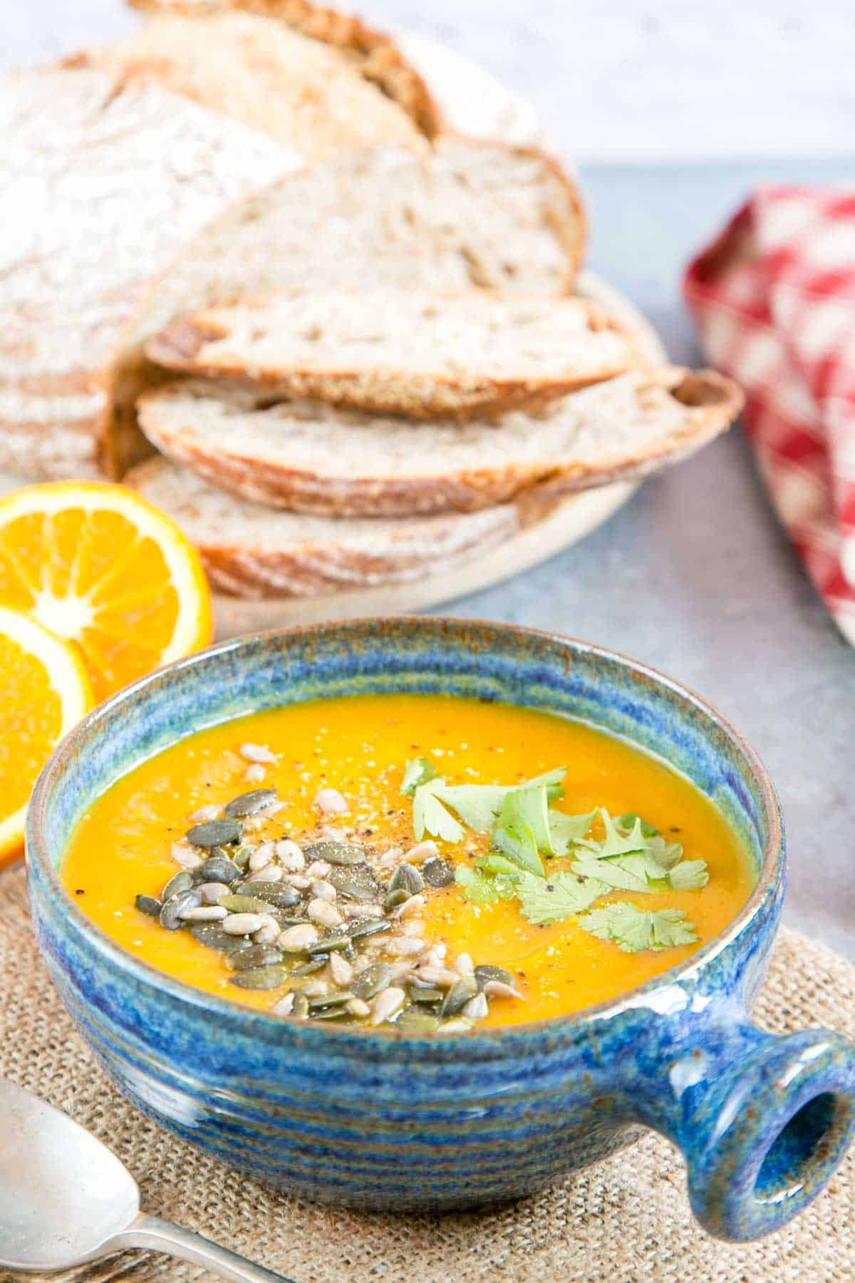 Spiced butternut squash soup served in a blue glazed bowl that contrasts with the orange soup.