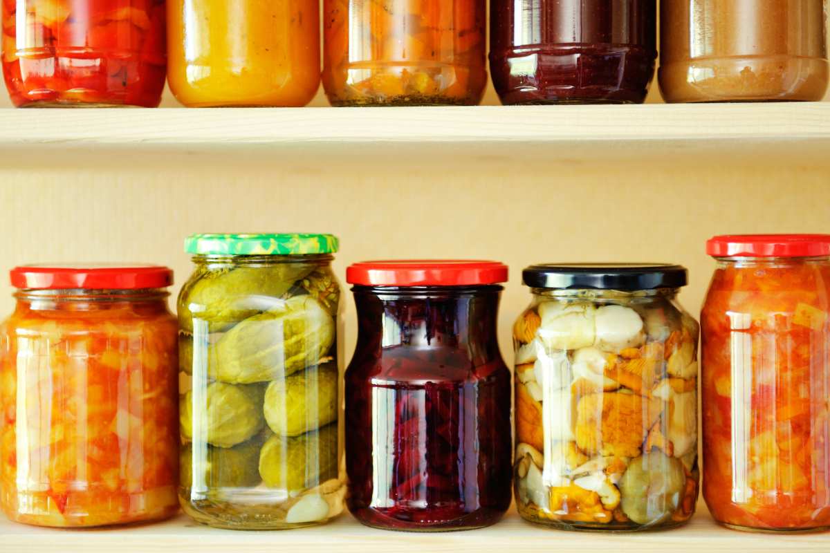 Jars of pickled vegetables on a shelf.