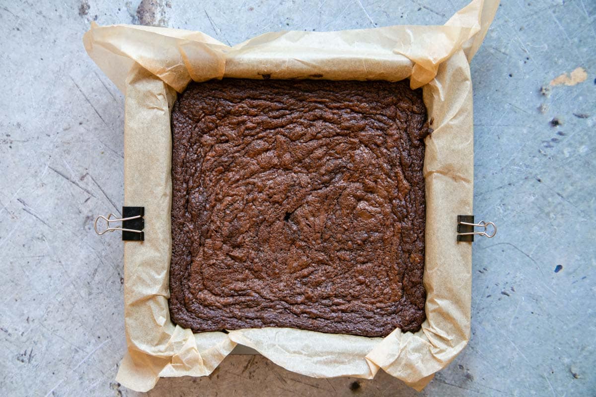 The baked brownie is risen at the edges and papery on the top, with an attractive swirl.