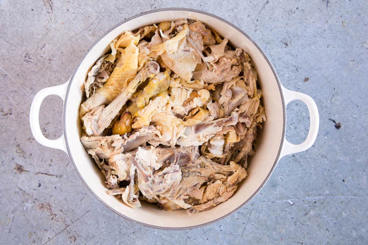 The broken chicken carcasses in a stock pot.