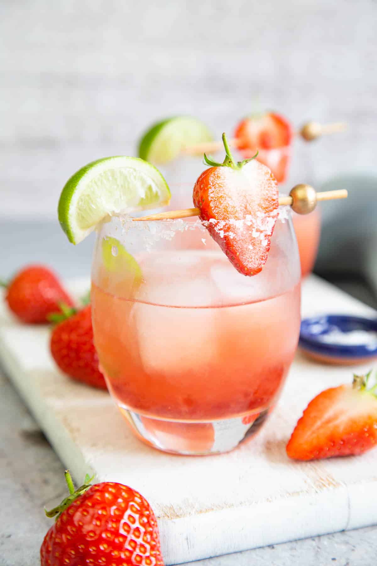 A generous garnish of fresh strawberries and lime wedges makes these jam margaritas look really special.