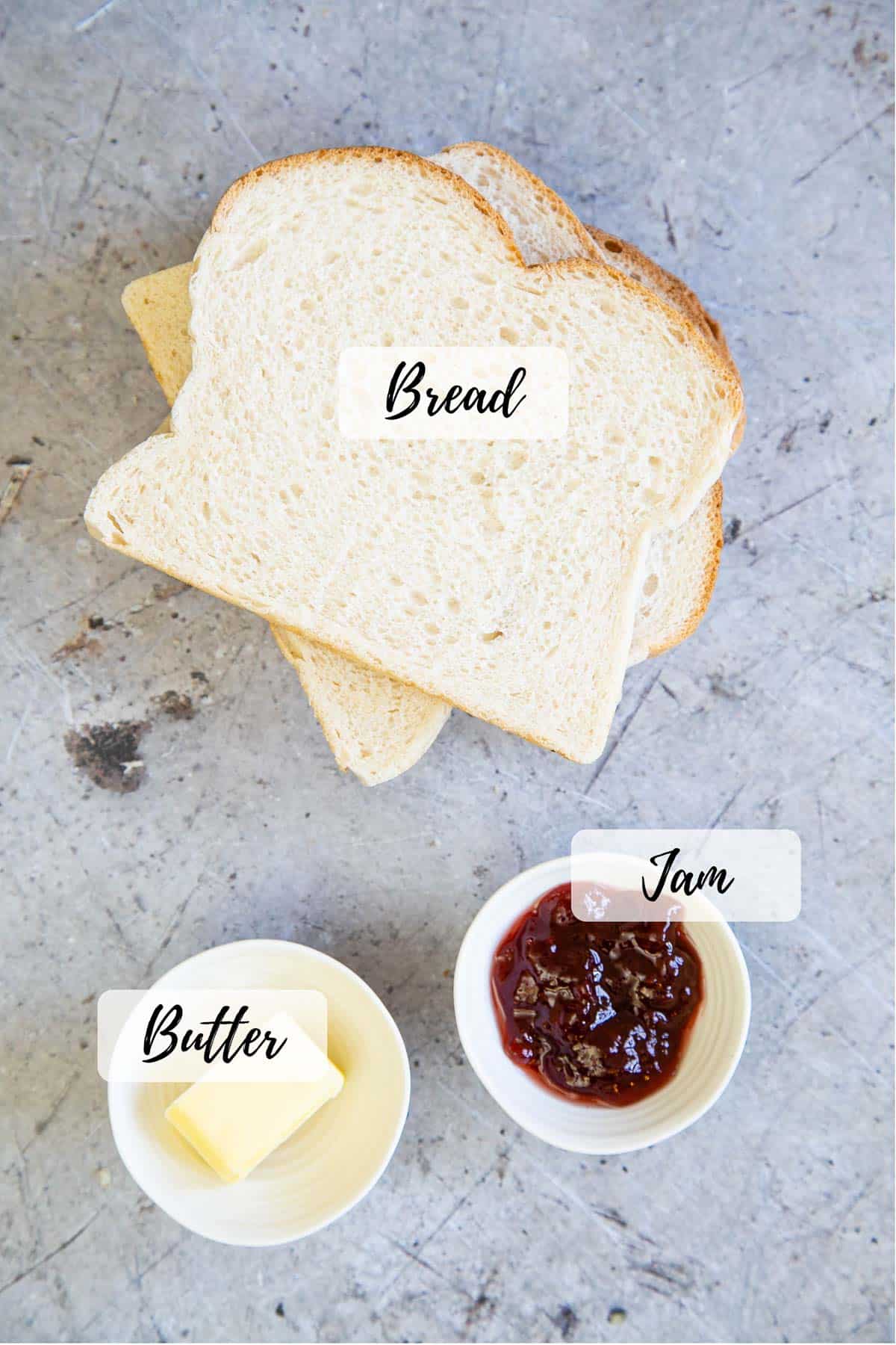 Ingredients for the perfect jam sandwich: soft white bread, red jam and butter.