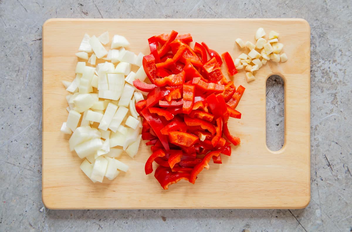 Chopped onion, red pepper and garlic, ready to cook. Chopping evenly helps with even cooking.