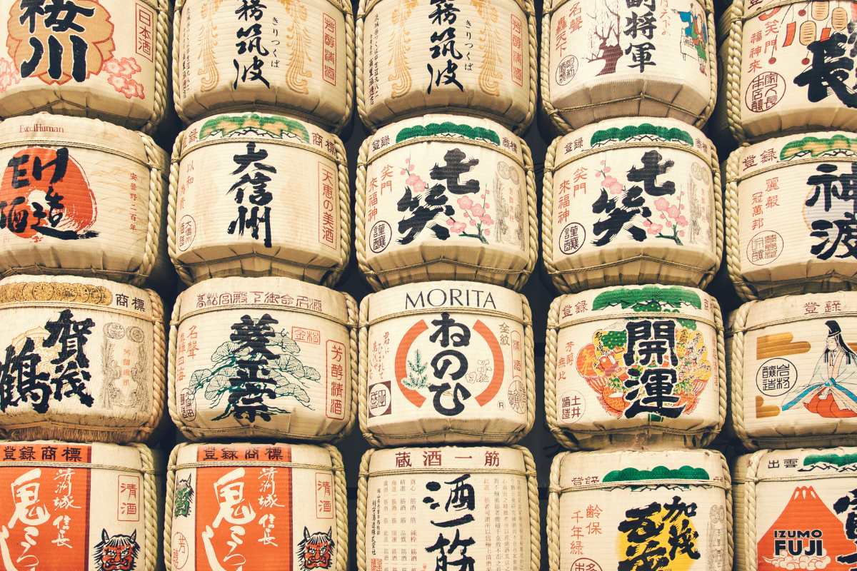 Stacks of sake barrels with Japanese print and distinctive designs.