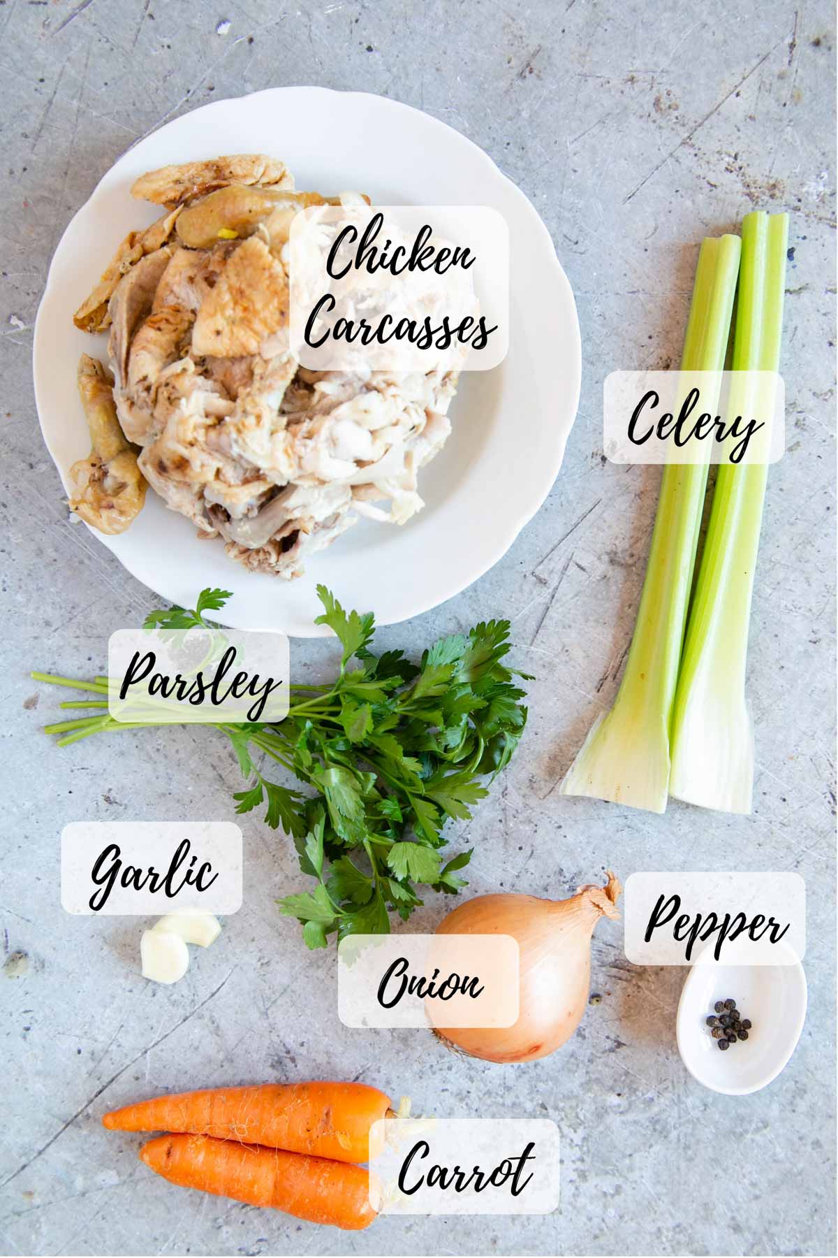 Ingredients for pressure cooker chicken stock: chicken carcasses, celery, pepper corns, onion, carrot, parsley and garlic.