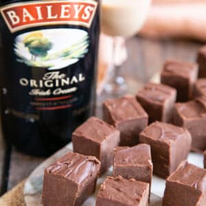 Squares of delicious Irish cream fudge with a bottle of Baileys Irish cream liqueur