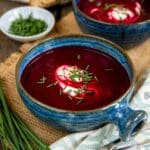 Tempting bowls of ruby red beetroot soup with sour cream and chives.