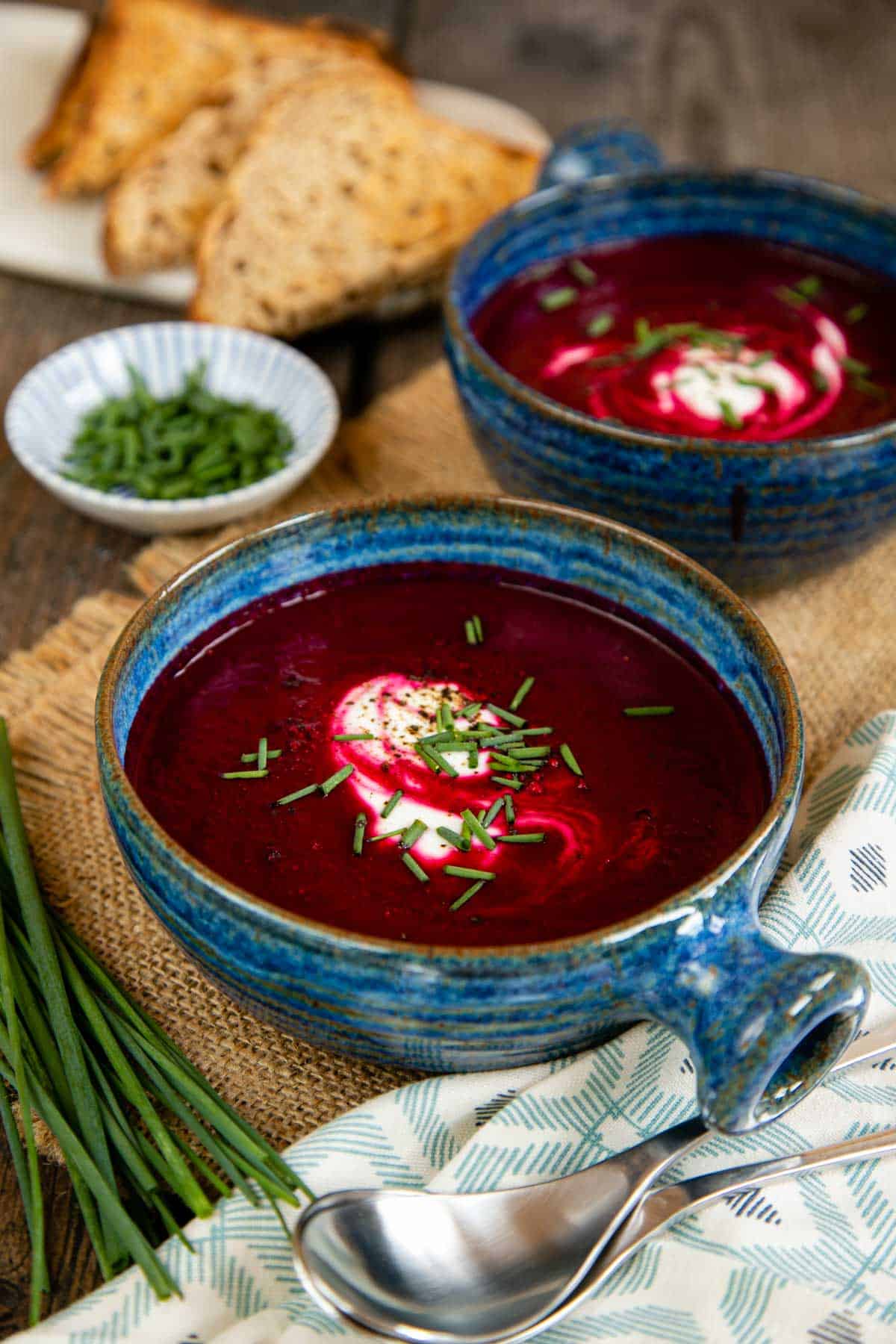 Striking ruby red beetroot soup served in blue bowls with a garnish of sour cream and chives for fabulous contrast.