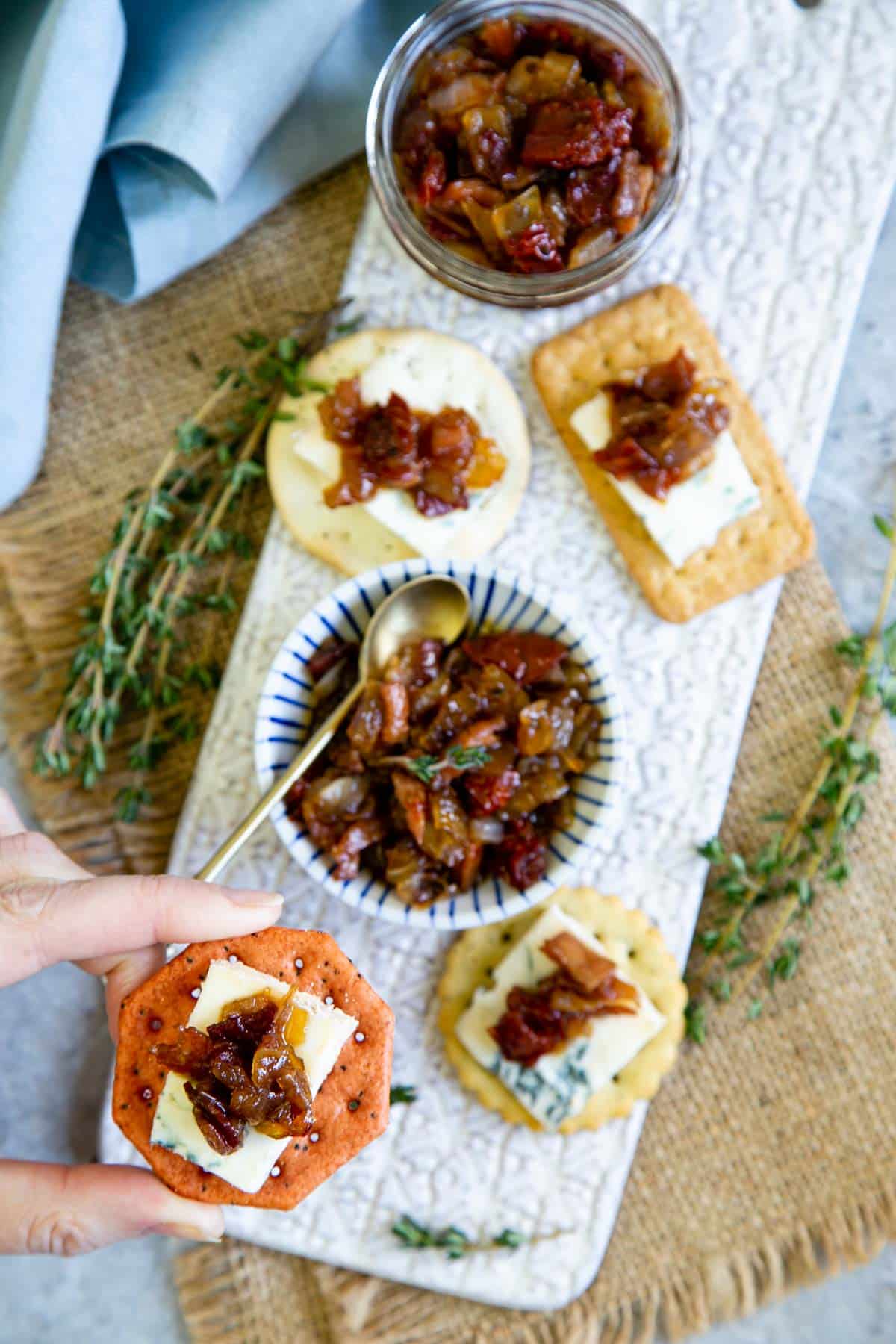 Cheese and crackers on a pretty presentation board with delicious tomato and bacon jam