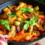 Chicken chorizo pasta in a meltingly creamy tomato and pepper sauce, scattered with green herbs.
