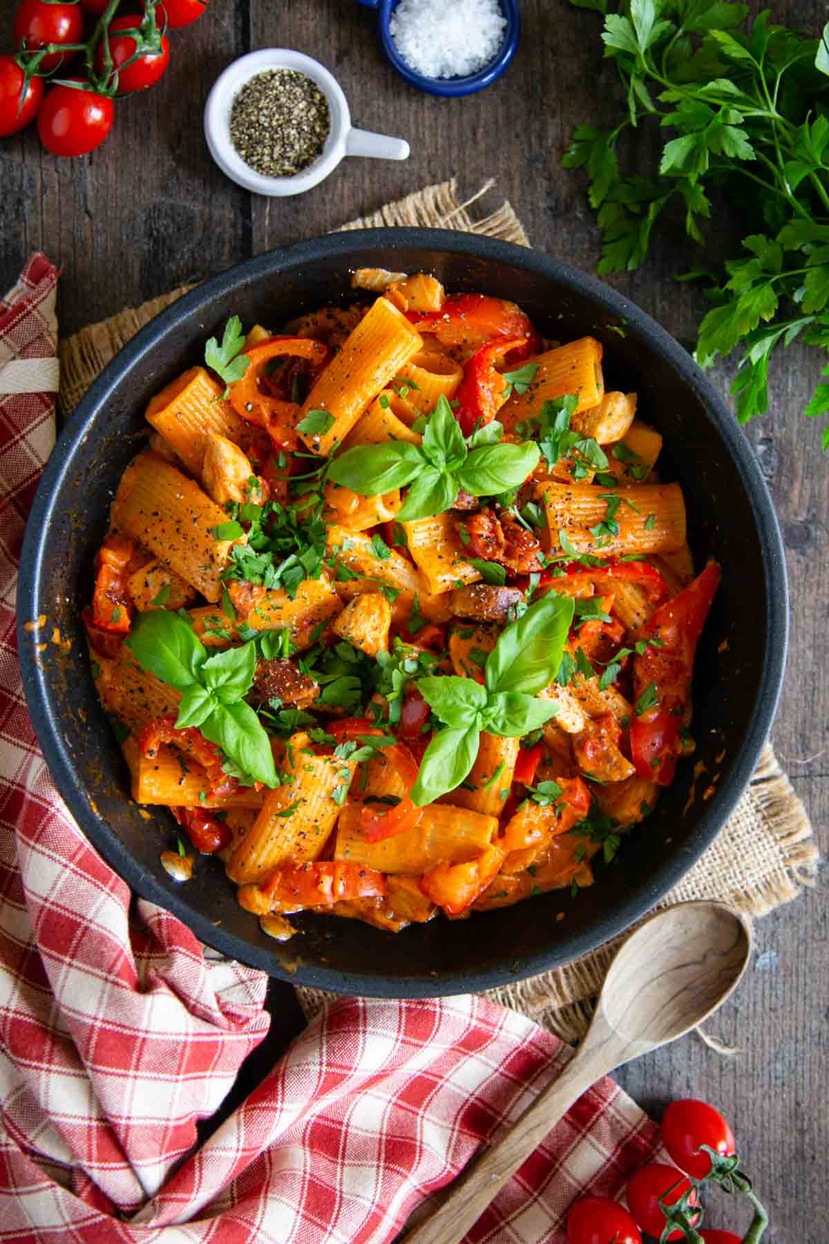 Chicken chorizo pasta, rigatoni in a rich red sauce flecked with peppers, dark slices of chorizo and a scattering of fresh green herbs.