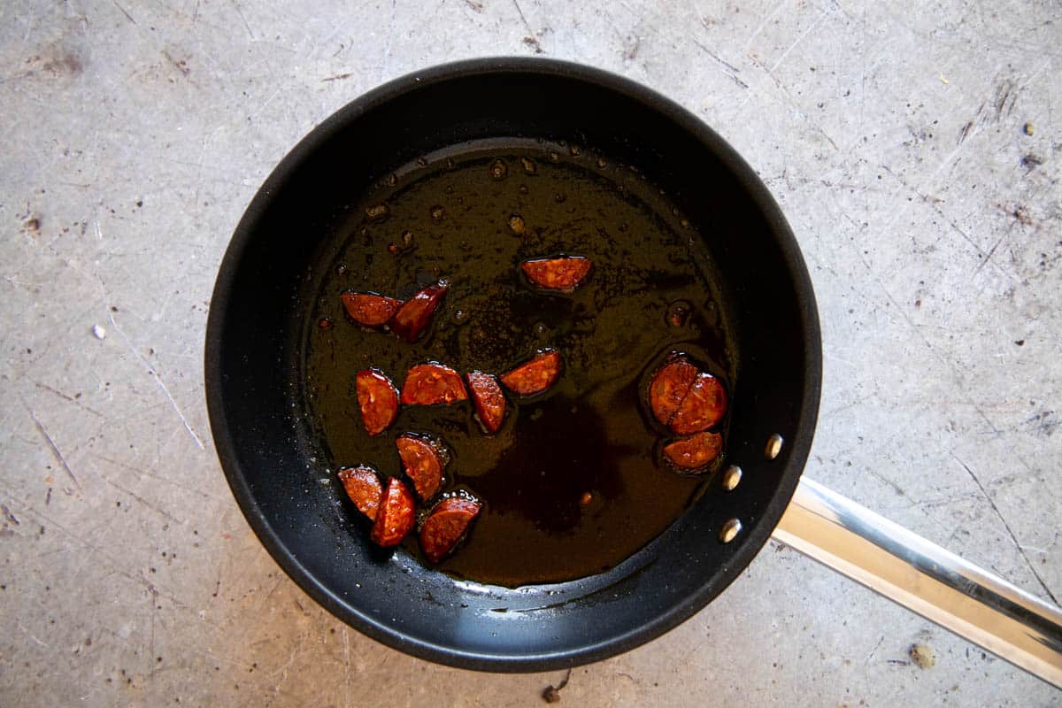 The chorizo frying in the pan.