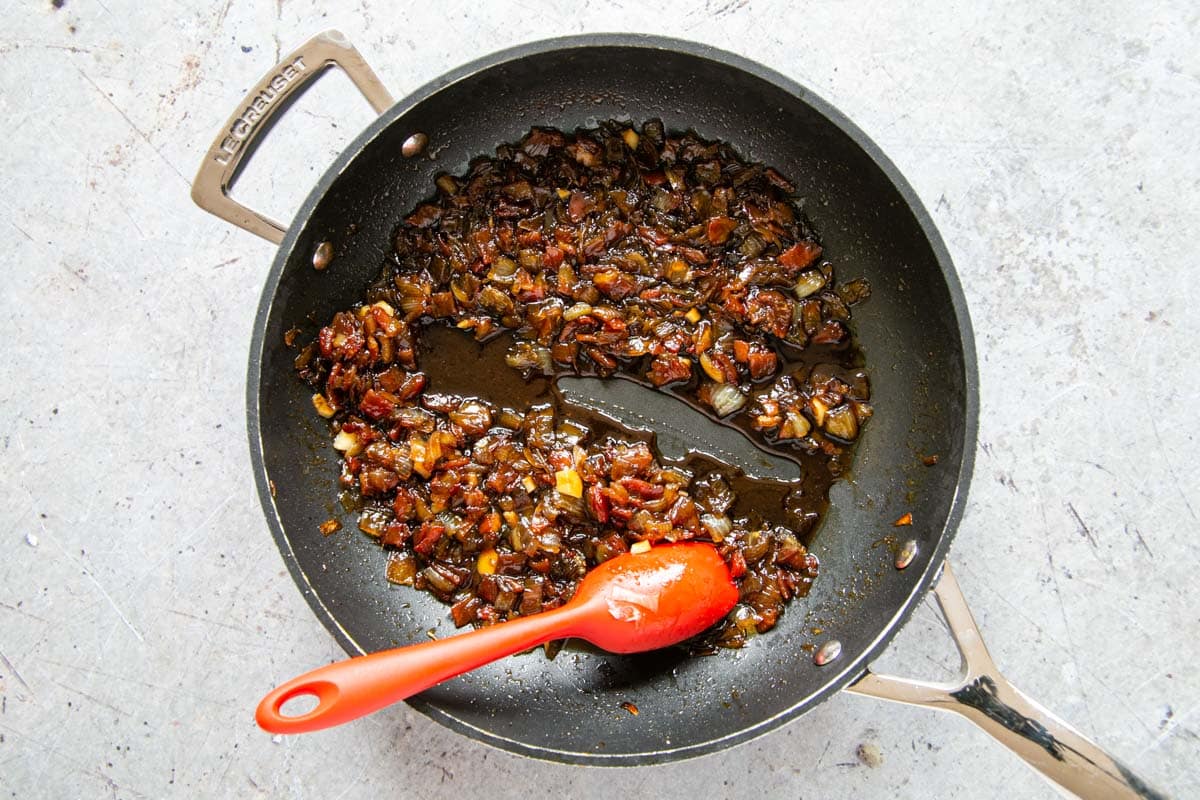 Drawing a spatula across the base of the pan leaves an empty space. If the syrup does not flood back into the gap too quickly, the bacon jam is ready.