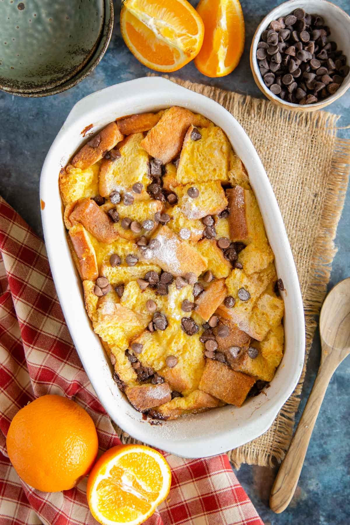 Chocolate orange bread and butter pudding from above, with cut oranges and chocolate chips.