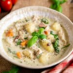 A dish of chicken gnocchi soup, creamy and vibrant with colourful vegetables and light gnocchi dumplings.
