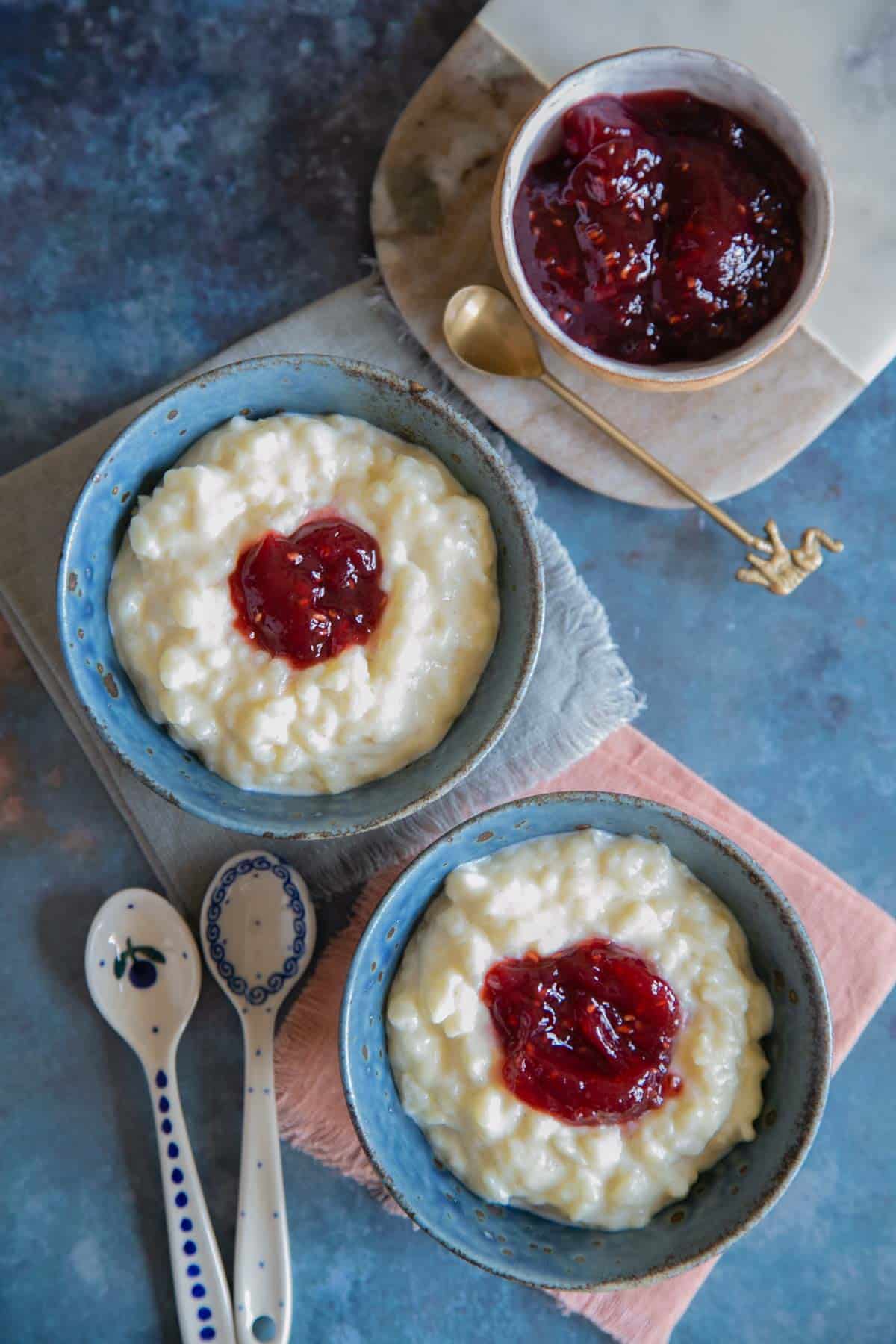 A view from above of a table spread with bowls of creamy rice pudding and homemade jam.