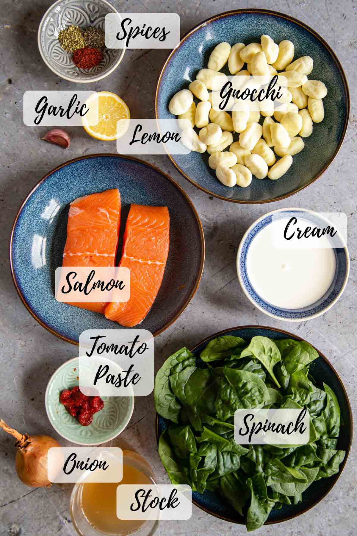 Ingredients for creamy salmon gnocchi: gnocchi, cream, spinach, onion, oil, salmon, lemon, garlic, herbs and spices