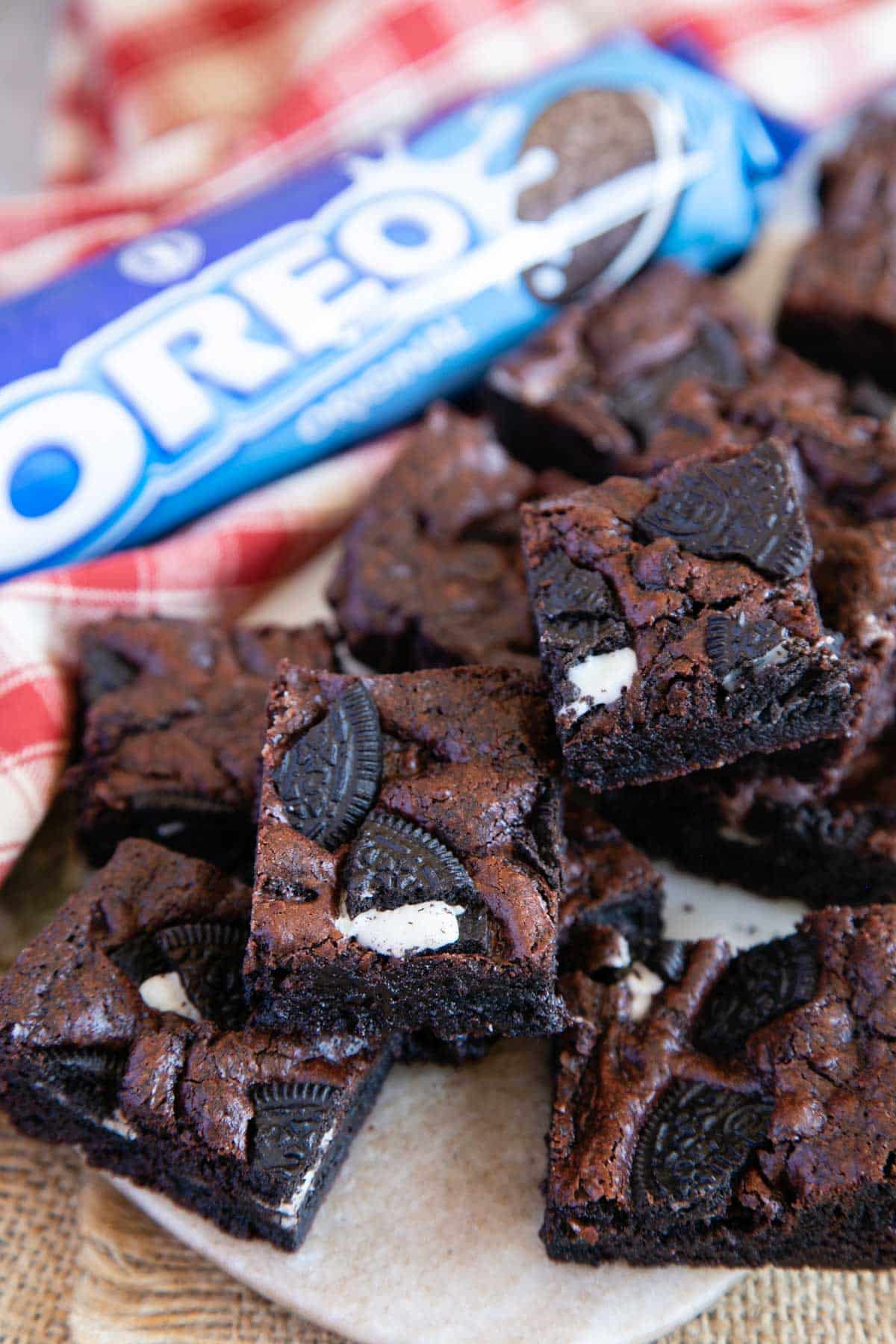 A pile of cookies and cream brownies next to a packet of Oreo biscuits - irresistible.