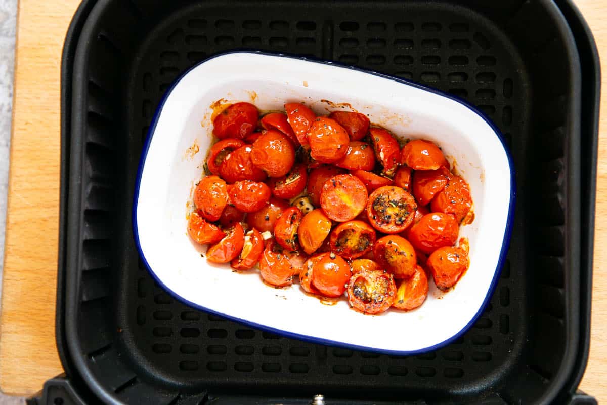 The cooked tomatoes have shrunk in size and collapsed, forming a sauce of the juices.