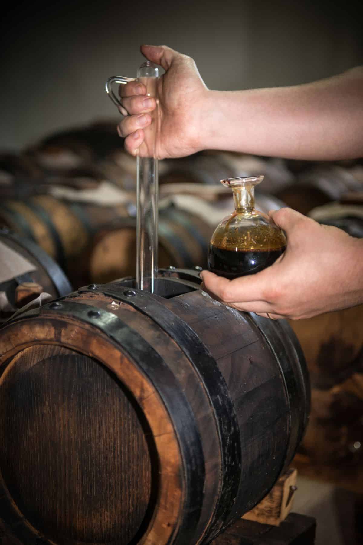 Taking balsamic vinegar from the cask where it is aged.