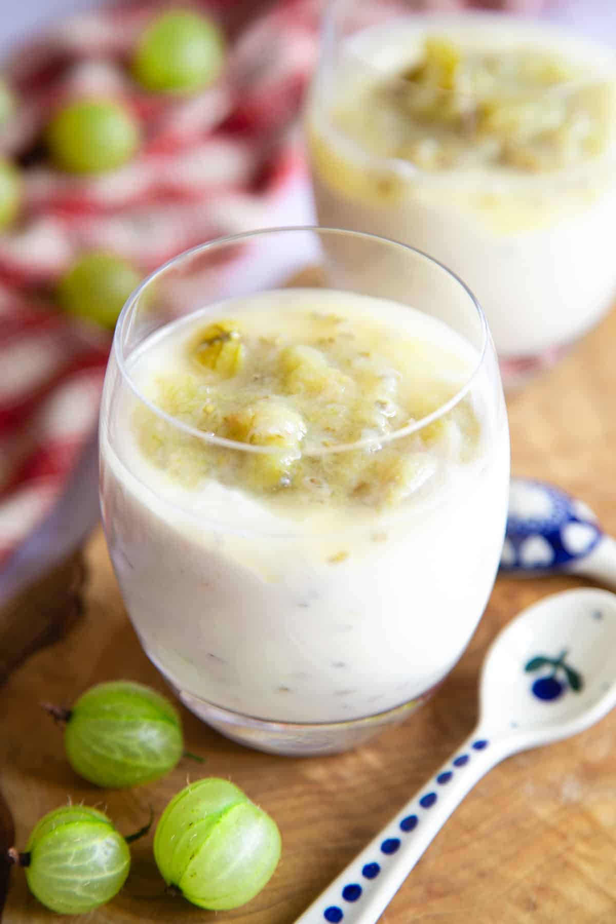 Rich and creamy gooseberry fool served in an elegant glass with extra gooseberry compote on top.