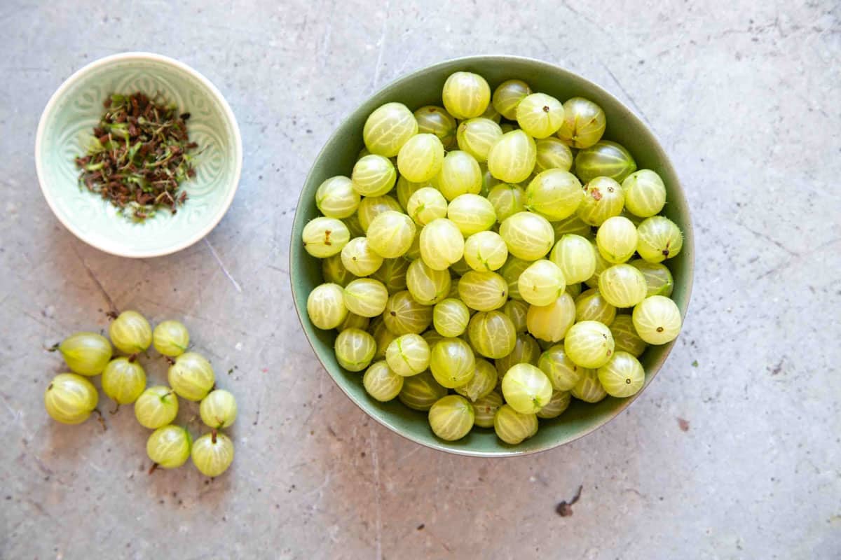 preparing gooseberries by topping and tailing them