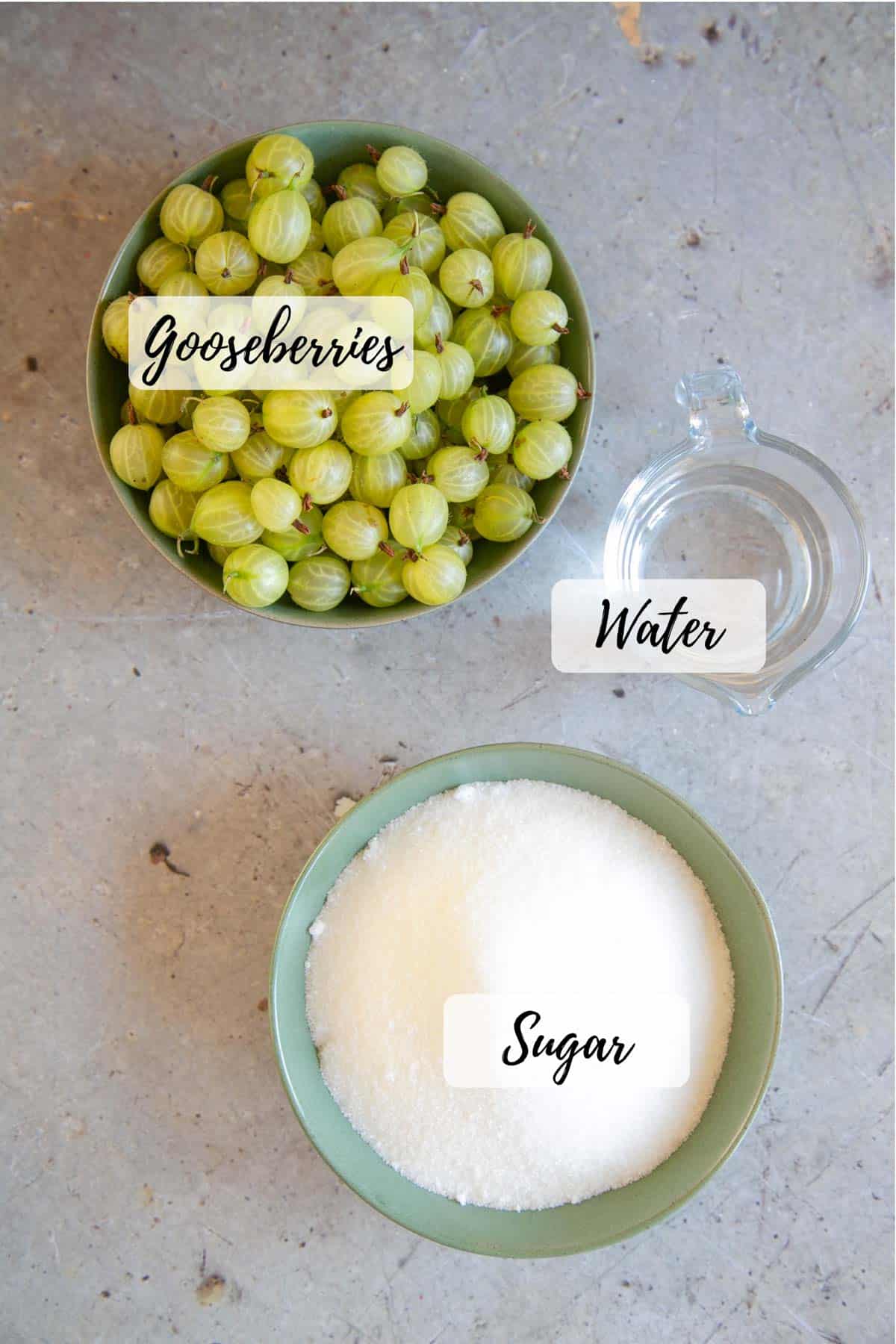 Ingredients for Gooseberry jam - bowls of gooseberries and sugar and a jug of water
