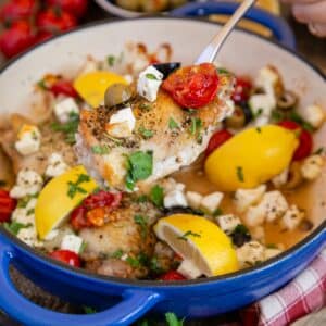 Greek chicken, bright and colourful in the casserole dish, in a delicious sauce formed from the juices.