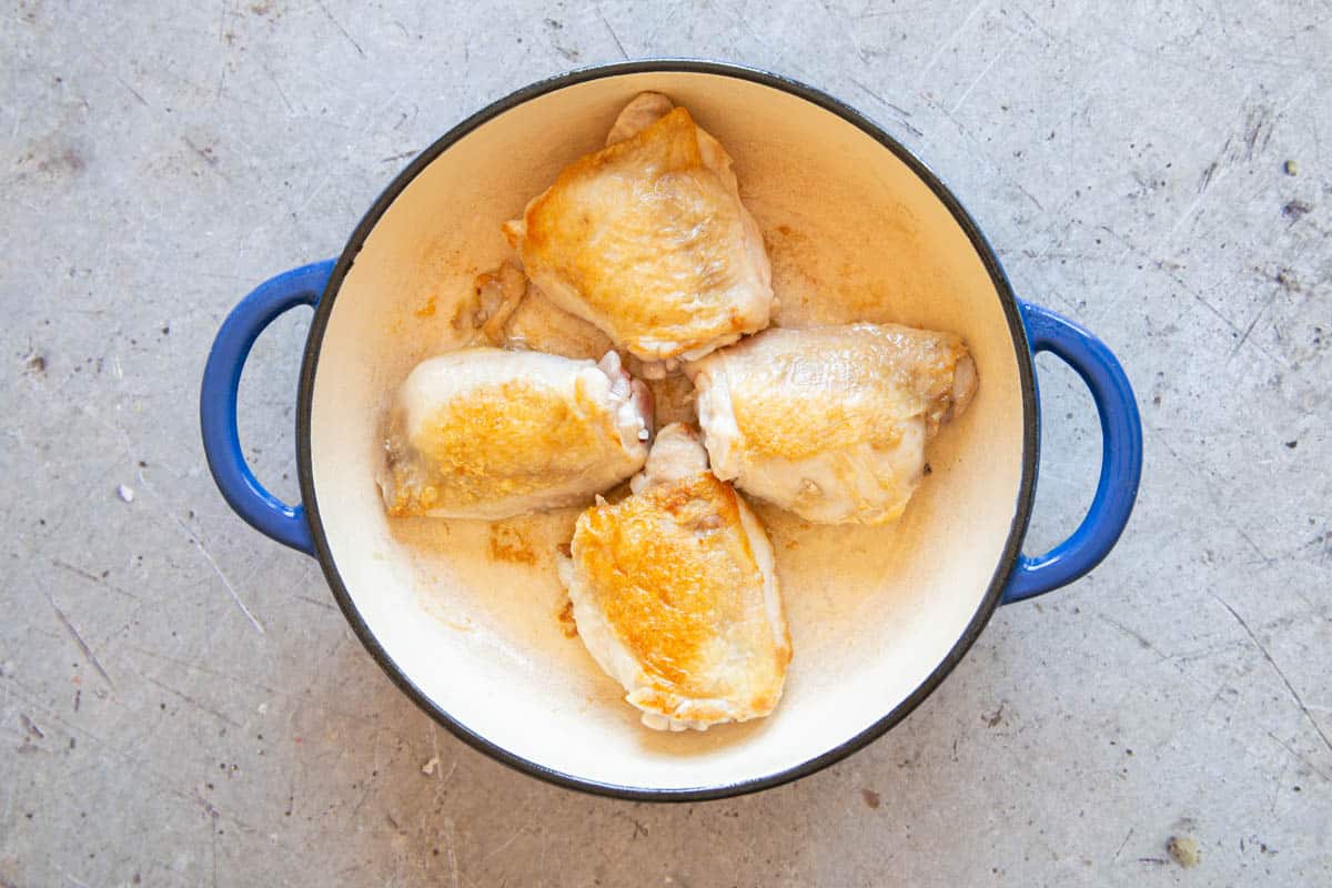 The chicken in the pan, the skin fried to a delicious pale gold.
