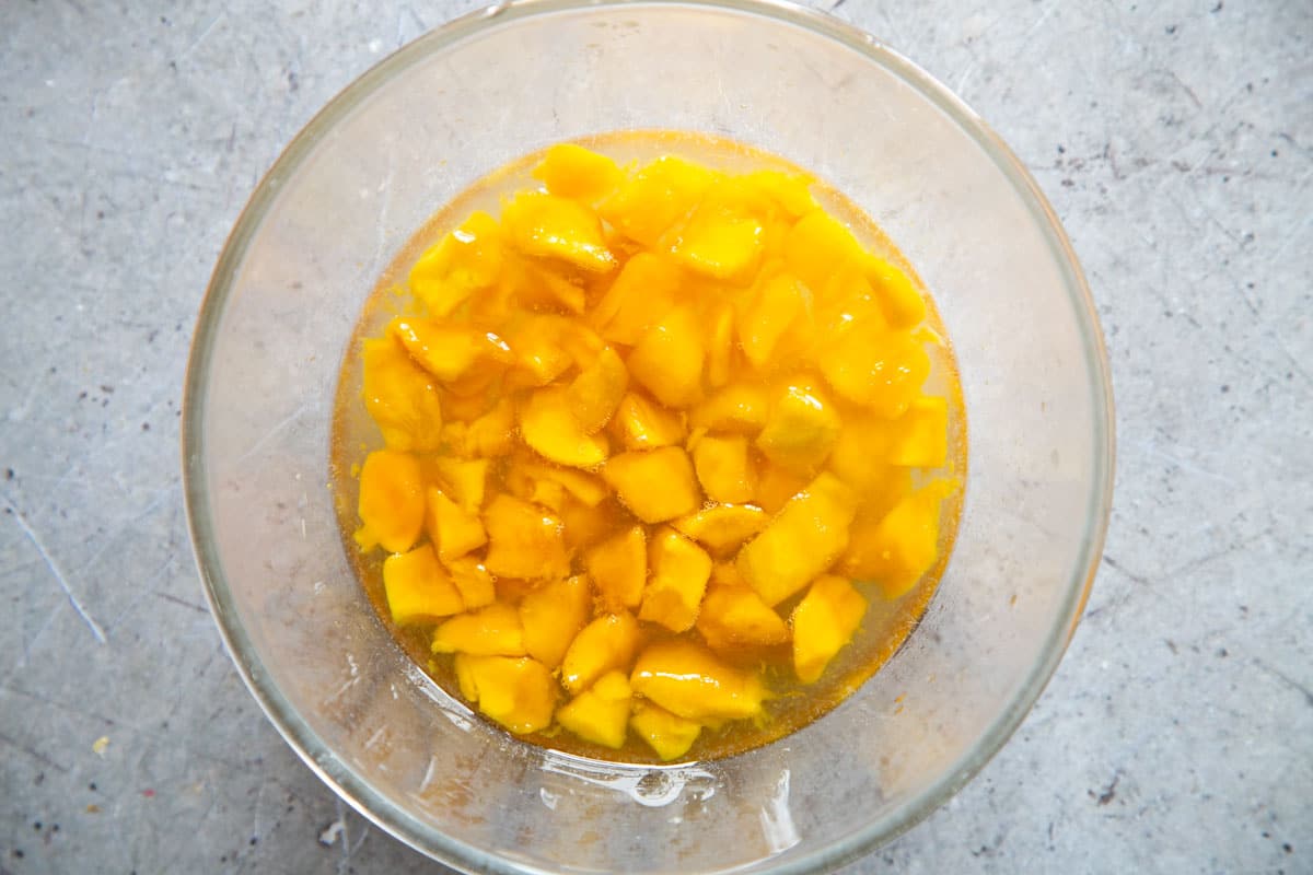 The macerated fruit in the bowl, the sugar fully dissolved to form a syrup.