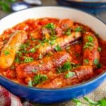 Sausage casserole - delicious traditional sausages in a rich, robust tomato gravy, served up from a cheerful blue casserole dish.