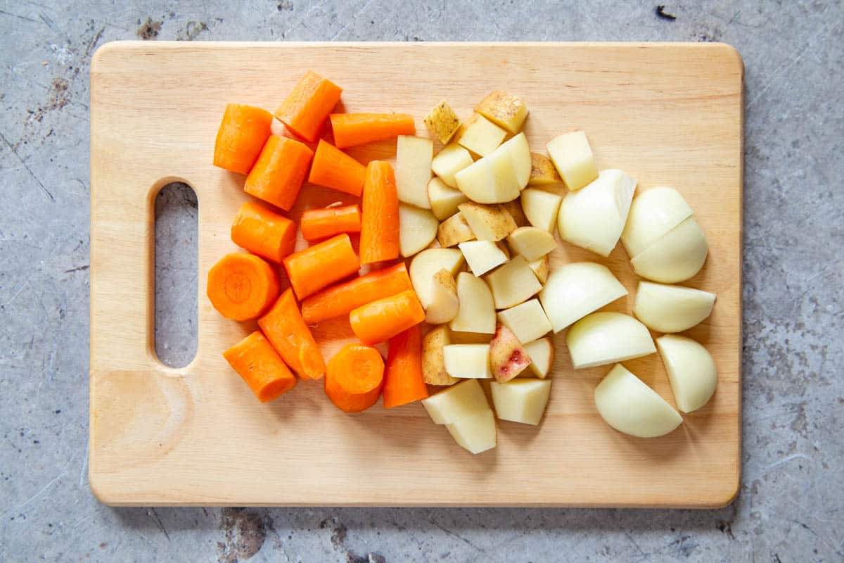 The vegetables peeled and chopped on a wooden board