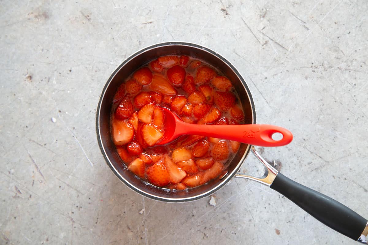 The cooked compote: the juices have formed a syrup with the sugar and the strawberries are tender but not broken down.