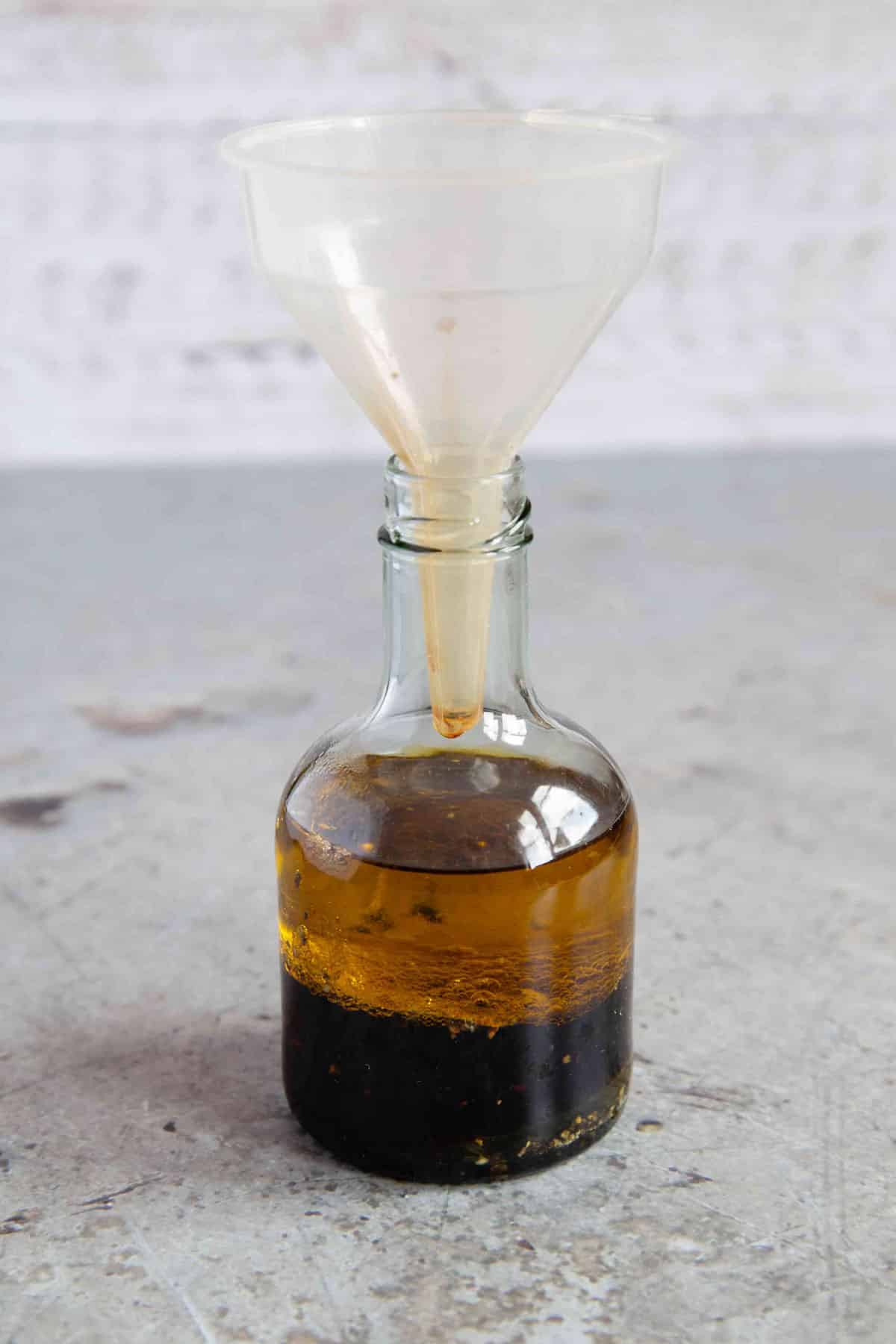 Using a funnel to put all the ingredients in the dressing bottle.