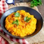 A dish of carrot and swede mash on the table, ready to serve.