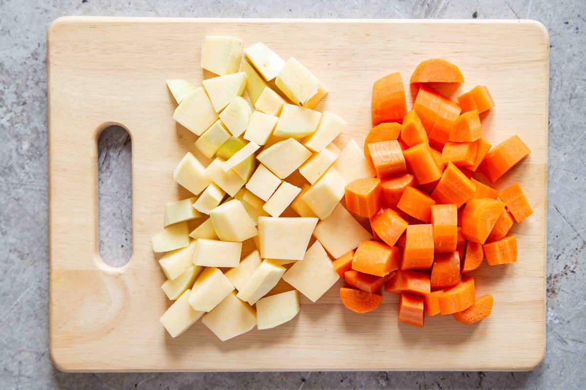 Peeled and chopped swede or rutabaga and carrots on a chopping board
