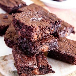A pile of chocolate brownies on a serving plate.